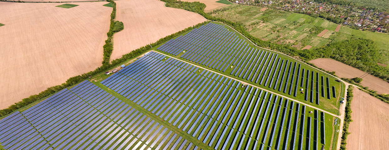 Aerial view of big sustainable electric power plant with many rows of solar panels